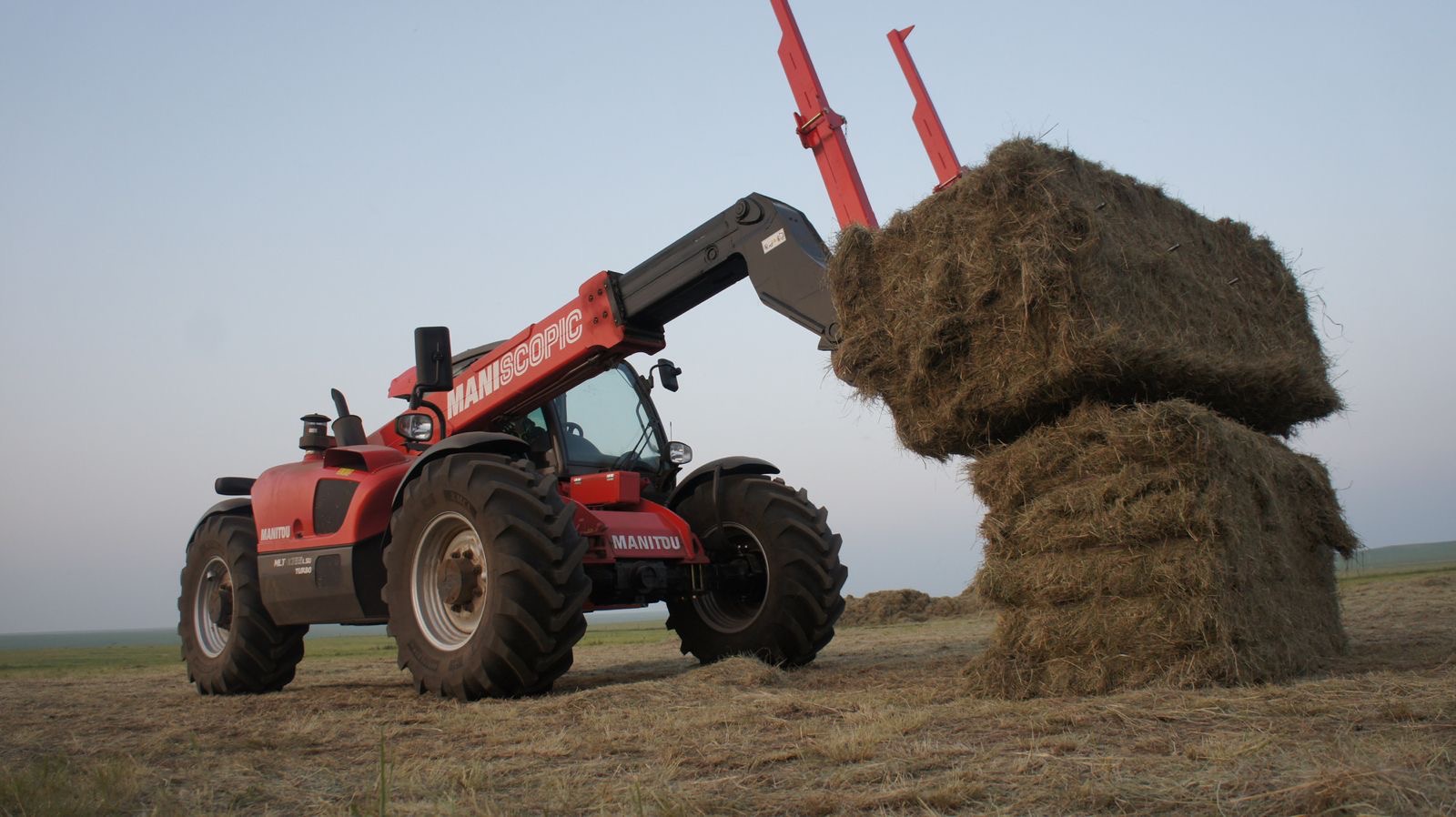 Vista lateral de la Manitou MLT-X 732 con implemento para pacas