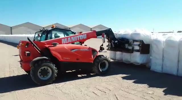 Telehandler Manitou moviendo materiales en patio industrial